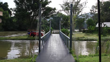 Vista-Simétrica-De-4k-De-Una-Pasarela-De-Acero-Que-Cruza-Un-Río-En-Tailandia