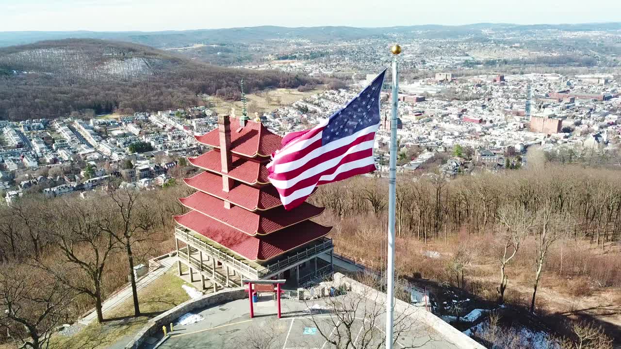 аэрофотосъемка над читающим пенсильванским азиатским храмом и американским флагом на фоне города 1