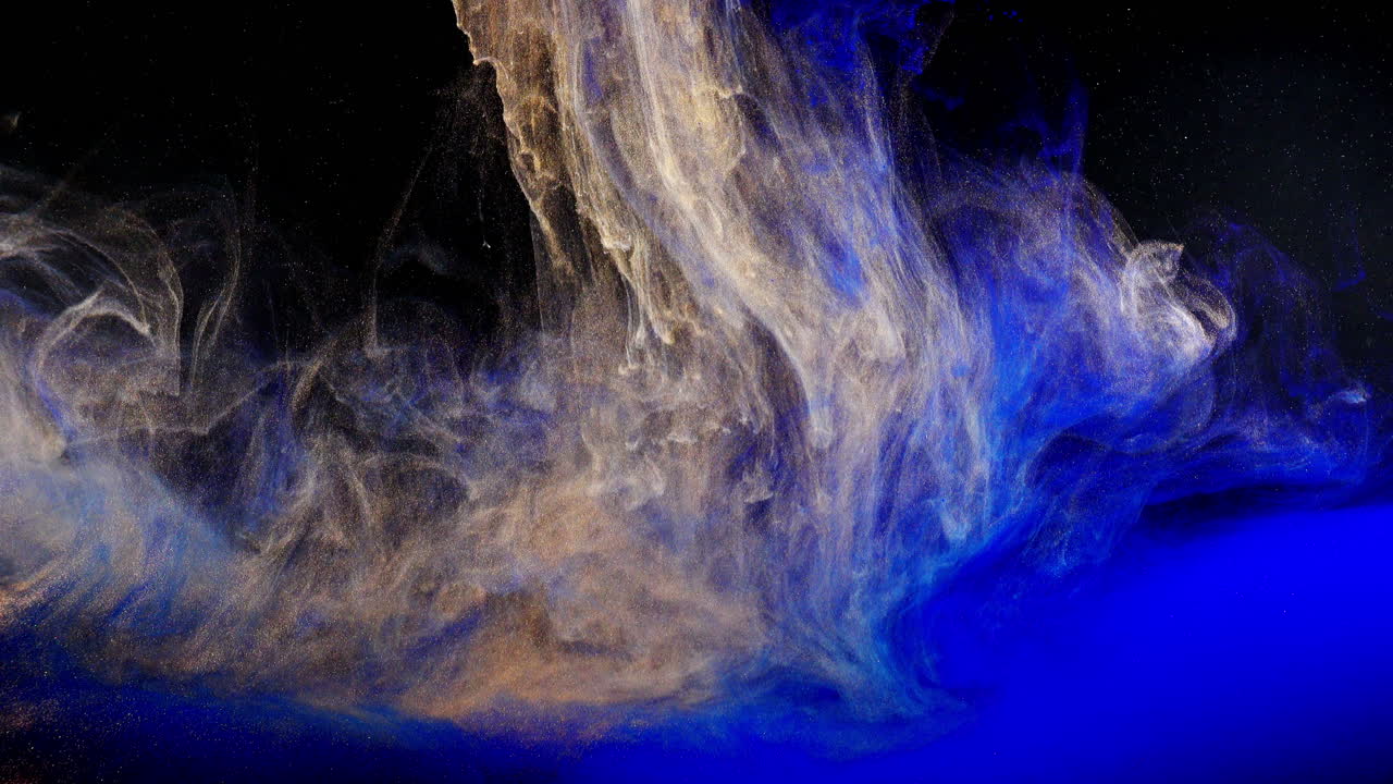Abstract Blue and Gold Ink Swirling in Dark Liquid