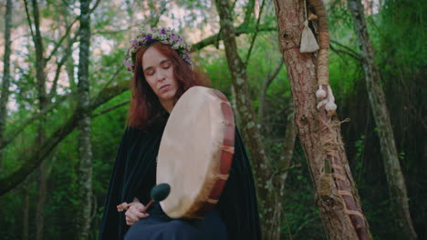 Niña-Druida-En-Un-Bosque-Tocando-Su-Tambor-Chamánico-Plano-Amplio-De-ángulo-Bajo