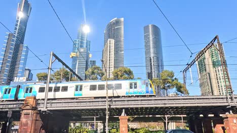 train moving through melbourne with skyscrapers in background