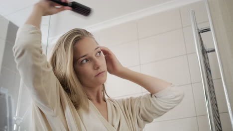 woman brushing hair in bathroom