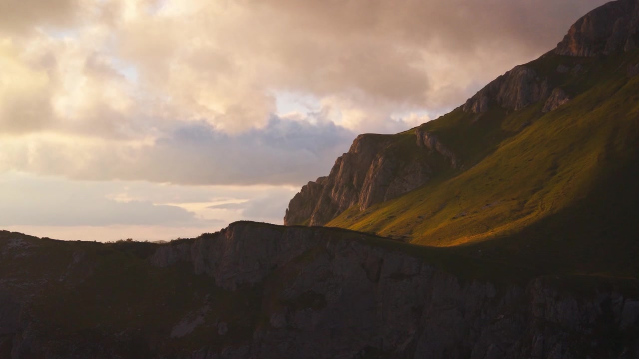 Kultainen auringonlaskun valo valaisee dramaattisia vuorenrinteitä ja kallioita Durmitorin kansallispuistossa, Montenegrossa.