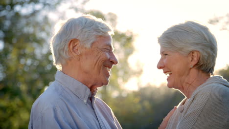 ein romantisches senior-paar, das in slowmotion gegen die sonne geschossen wurde