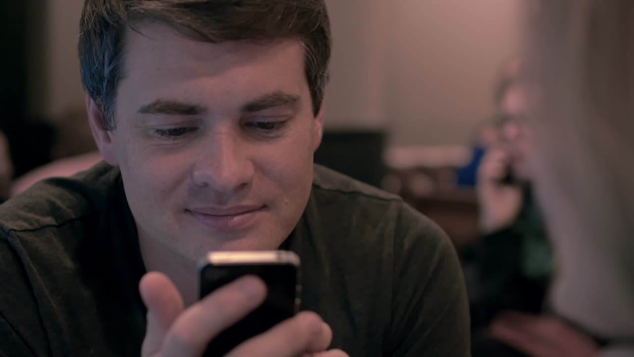 joven usando el teléfono celular con una mirada feliz