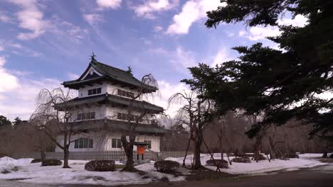 wide open view of hirosaki castle during winter with person walking castle grounds