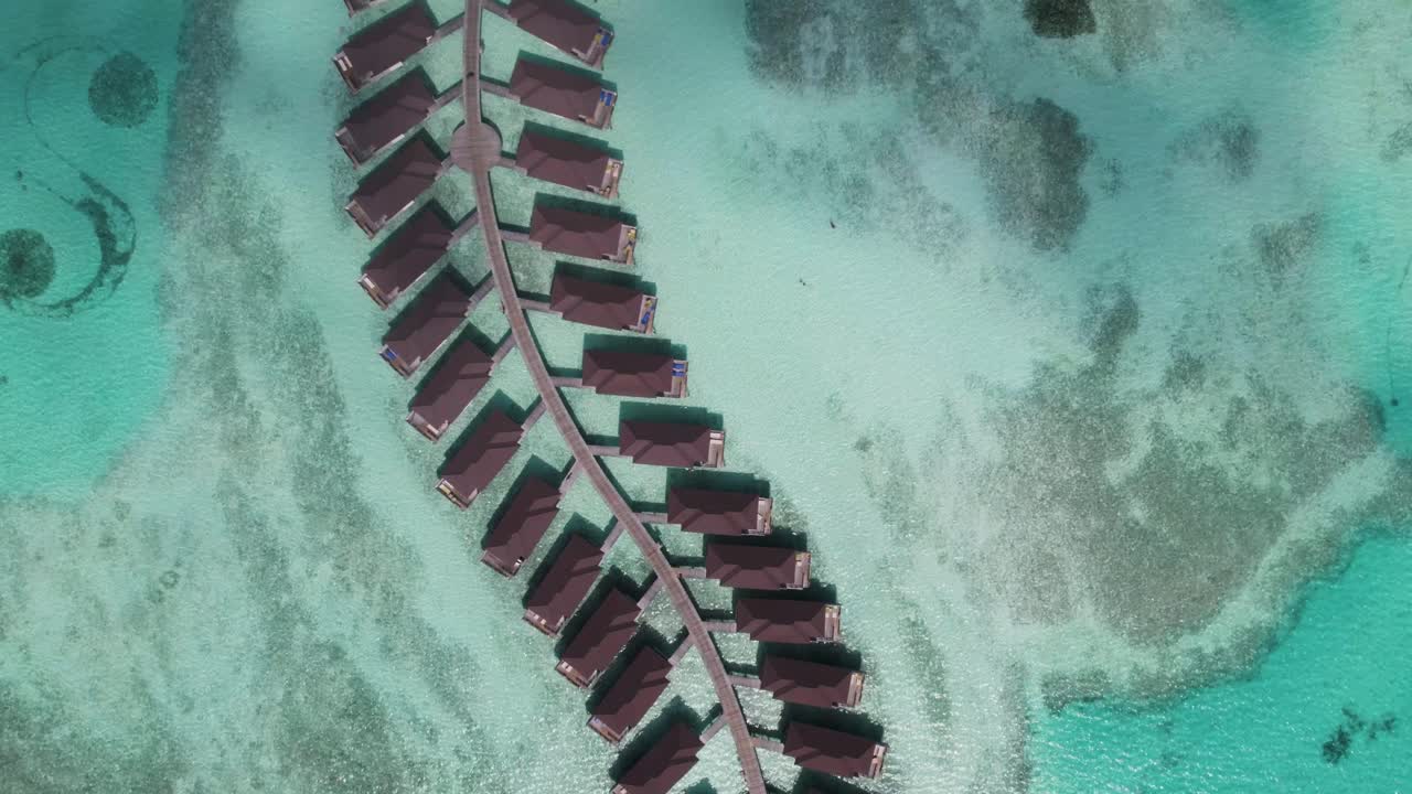 bungalows sobre el agua en las maldivas rodeados por el mar turquesa, vista aérea