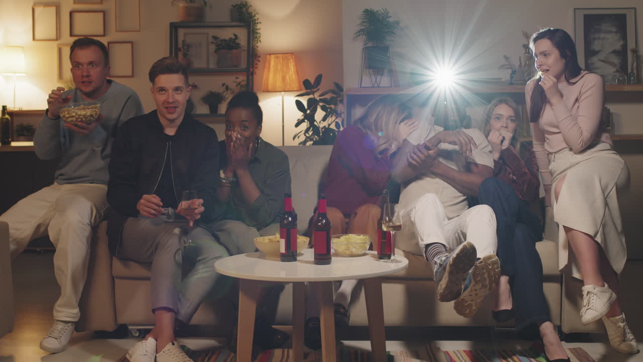 Group of People Watching Scary Movie at Home