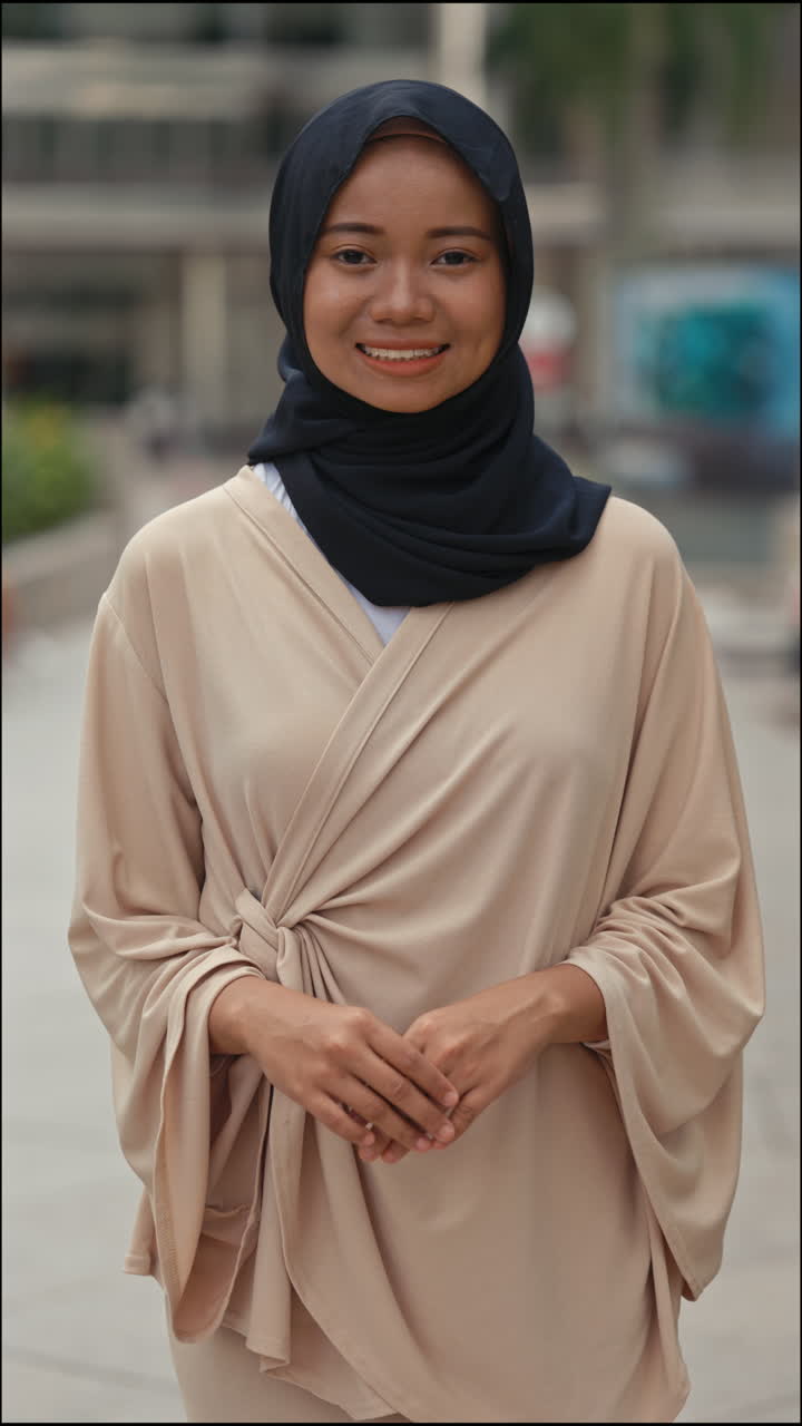 Portrait of a smiling woman in a hijab outdoors