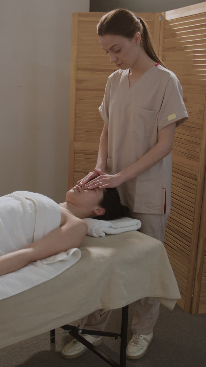 A woman receives a relaxing head and face massage at a spa
