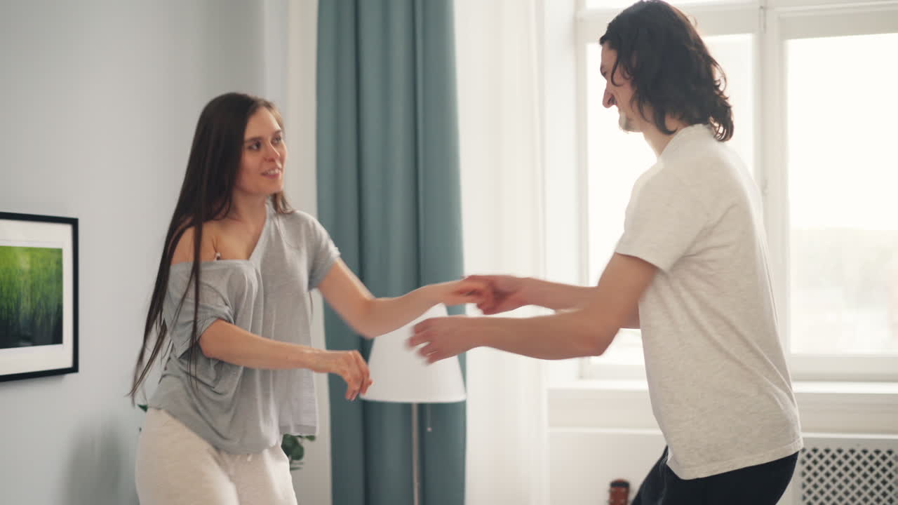 una pareja feliz bailando en casa.