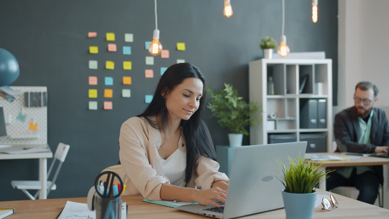 mujer trabajando en una computadora portátil en una oficina moderna