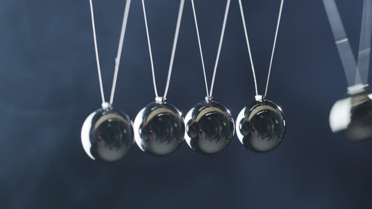 뉴턴의 요람 클로즈업 - 금속 공이 서로 부딪혀 에너지 절약 효과를 나타냄