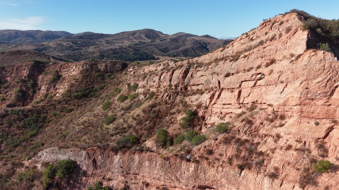 Aerial drone footage soaring above exposed rock faces and rugged terrain in Black Star Canyon, California, highlighting geological layers and steep canyon walls in the wilderness