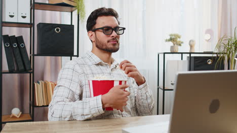 tired business man taking break from work wearing 3d glasses earing popcorn watching film on laptop