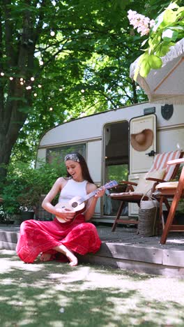 woman playing ukulele on a camping trip