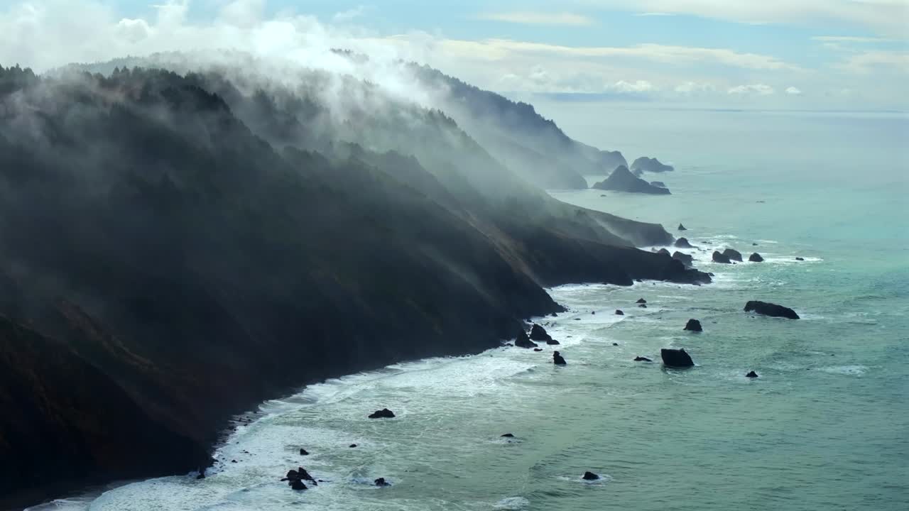 Rugged coastline Lost Coast Trail USAL Beach campground 4wd aerial drone California cloud layer blue sky mist rain fog PNW waves crashing morning Chimney Rocks nature landscape forward pan up motion