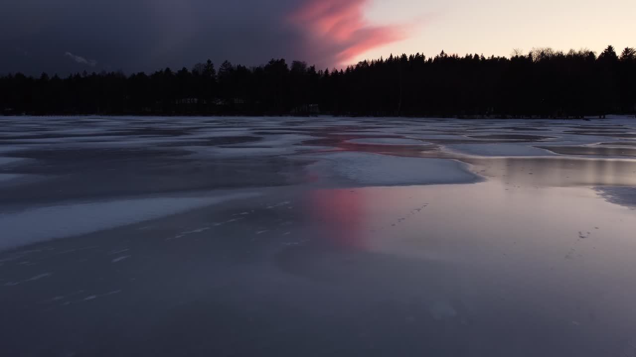 Patches of snow on a frozen lake after the sunset