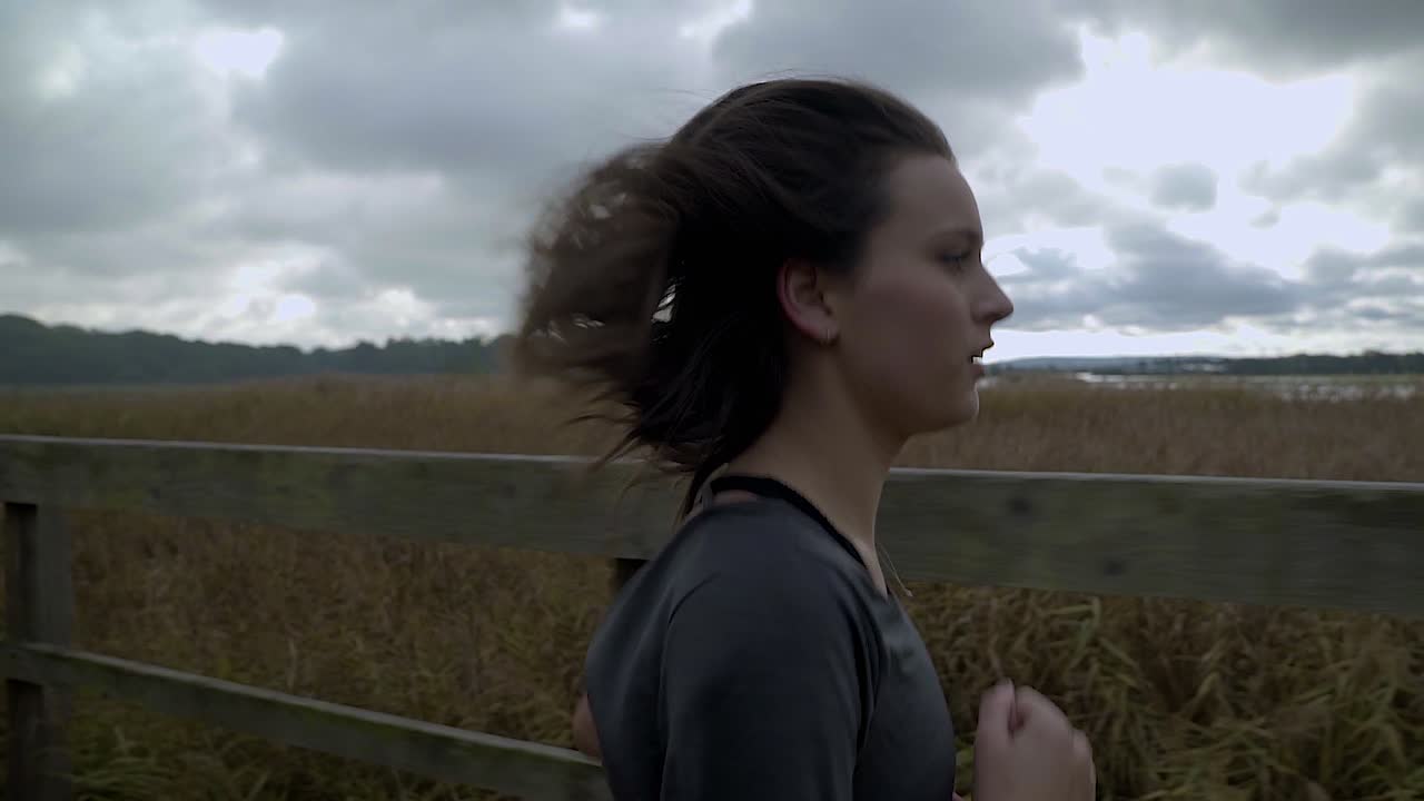 female runner running through the forest