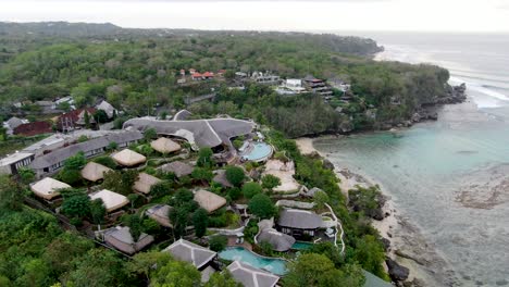 Luxury-lodging-on-cliff-in-Padang-Padang-beach,-Bali,-aerial-view