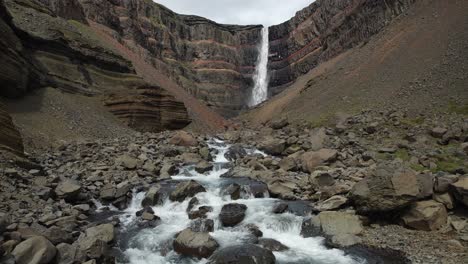 der herrliche hengifoss-wasserfall in island mit dem hengifossa-fluss im vordergrund