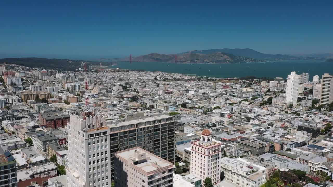 Stunning aerial footage of downtown San Francisco, showcasing iconic skyline under clear blue skies. Captivating views highlight skyscrapers and urban sprawl in vibrant daylight