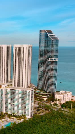 mix of high-rise and low rise buildings in the architecture of miami. beautiful residential area with splendid atlantic ocean at backdrop. vertical video