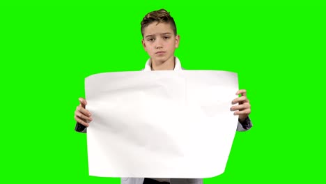 teenager holds an empty paper at green background