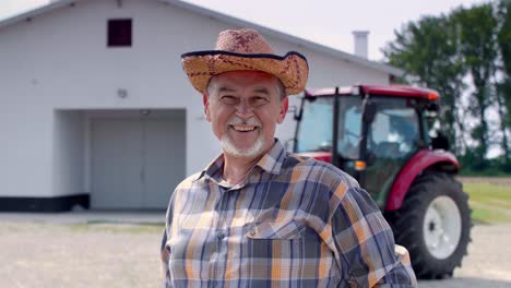 Portrait-of-cheerful,-senior-farmer-in-front-of-the-barn