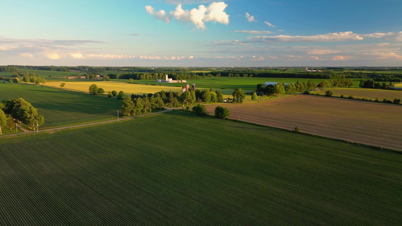 Terreno agricolo rurale con fattoria e coltivazioni al tramonto in Ontario, Canada