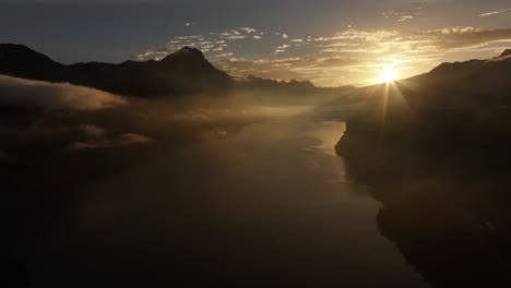 golden sunrise over calm walensee with silhouetted swiss alps, switzerland