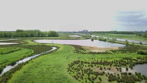 footage of flying up over the river and green savanna near the canal in holland