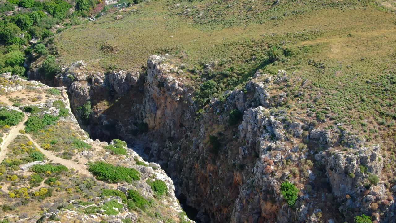 Vista aerea di una gola con il fiume sottostante, un canyon e un paesaggio aspro, ripresa da drone.