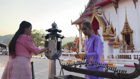 women praying at a temple in thailand