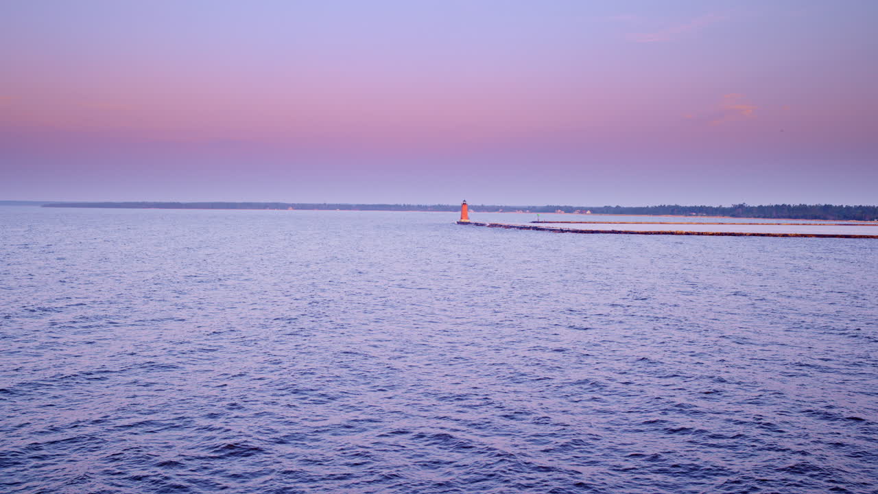 Drone shot flying over lake michigan towards the breakwater and lighthouse