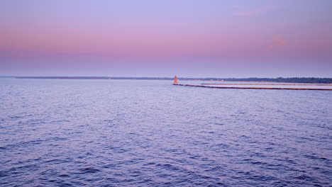 drone shot flying over lake michigan towards the breakwater and lighthouse