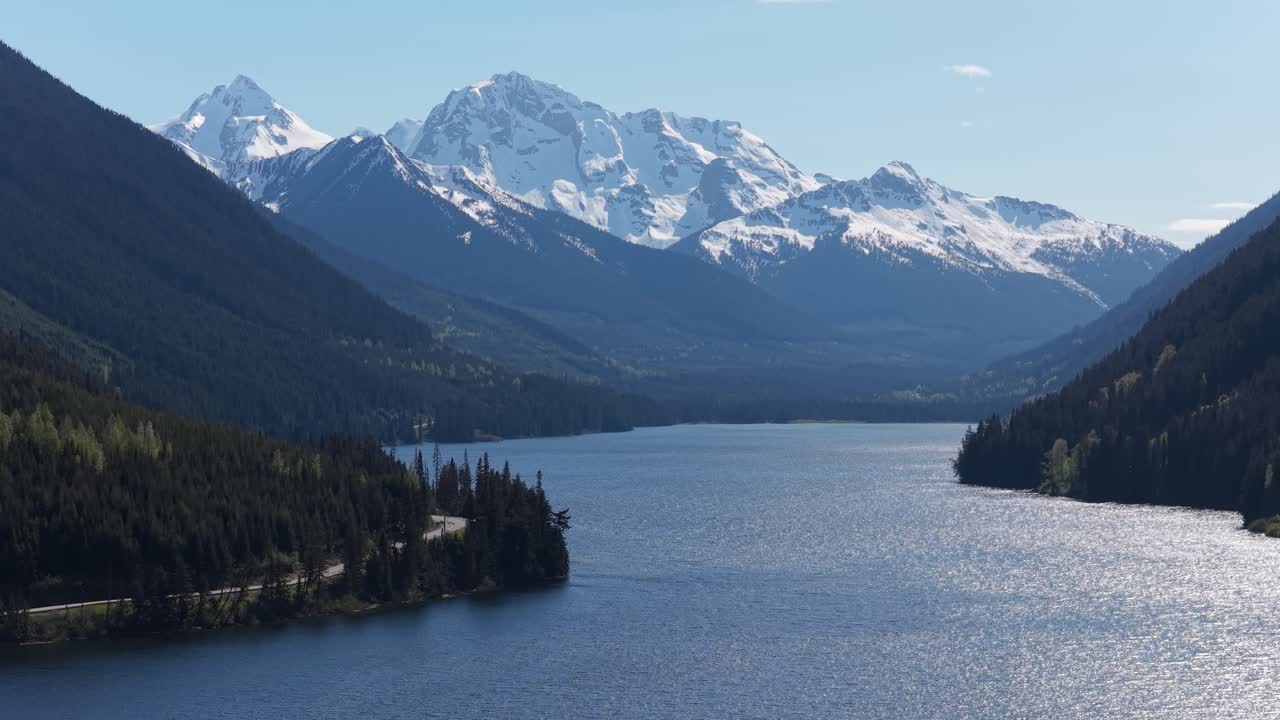 Majestic Snow-Capped Mountains Reflected in a Calm Lake with Dense Forests in British Columbia, Canada