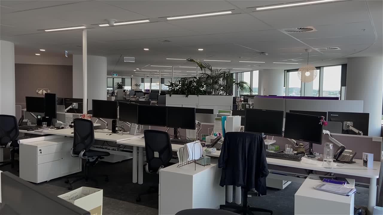 dolly de alta calidad disparó sobre escritorios vacíos en un edificio de oficinas grande y desierto con estaciones de trabajo desatendidas, durante el cierre pandémico del covid-19, con todos los empleados trabajando desde casa