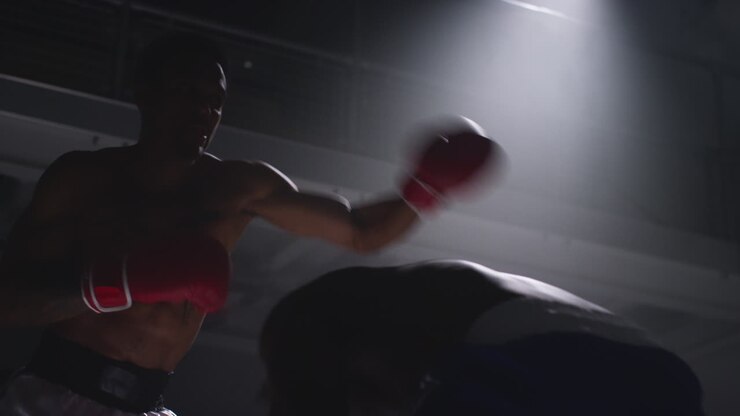 Close Up Shot Of Two Male Boxers Wearing Gloves In Boxing Ring Fighting In Boxing Match With Low Key Lighting 6