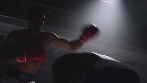 toma de cerca de dos boxeadores masculinos con guantes en el ring de boxeo luchando en un partido de boxe o con una iluminación de bajo nivel 6