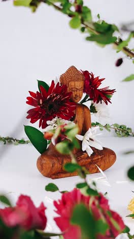 wooden buddha statue decorated with flowers