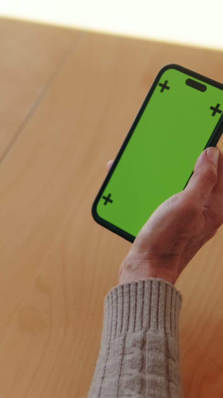 Persona che tiene uno smartphone con schermo verde
