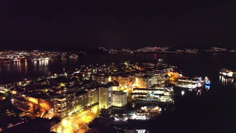 Nordnes-Gebiet-Und-Byfjorden-Bergen-Während-Des-Frühen-Silvesterabends---Schöne-Nachtantenne-Mit-Beleuchteter-Stadt-Und-Zufälligem-Feuerwerk-Im-Hintergrund-Der-Askoy-insel