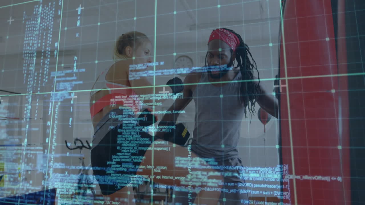 female boxer punching bag with coach guiding in fitness studio, displaying digital grid and code
