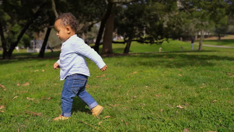 Niño-Jugando-Con-Pelota-En-El-Parque,-Tratando-De-Jugar-Pase,-Sonriendo