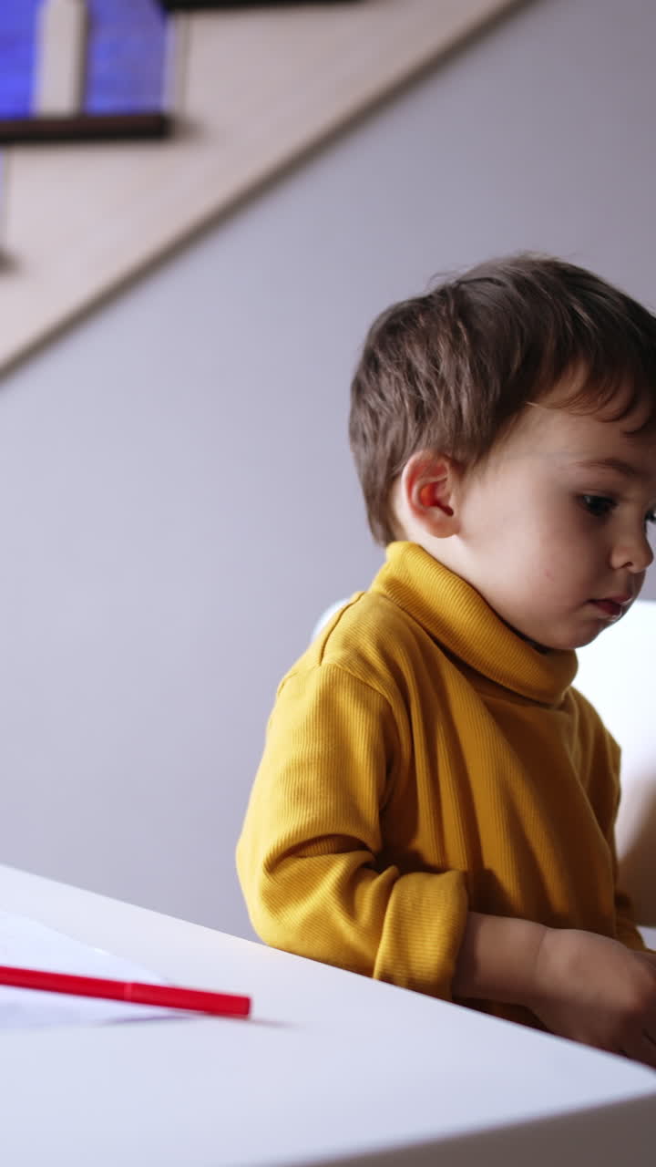 Un adorabile bambino dolce finisce di disegnare, posa la penna e vuole alzarsi