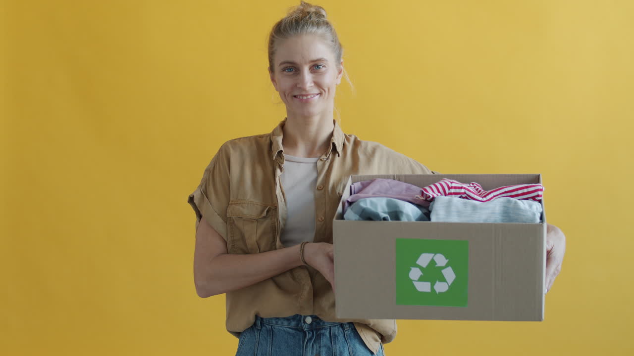 Woman Holding a Donation Box Filled with Clothes