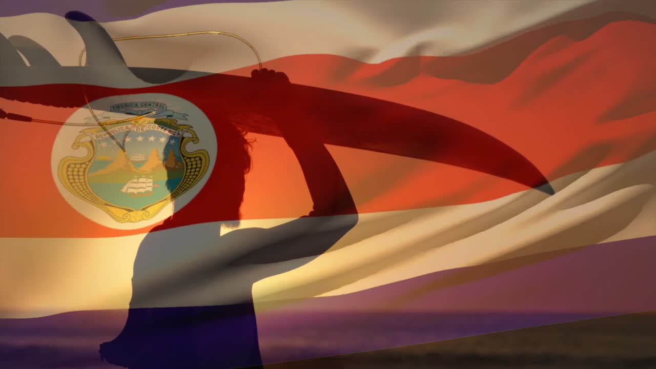 анимация флага коста-рики над кавказским мужчиной, держащим доску для серфинга на пляже