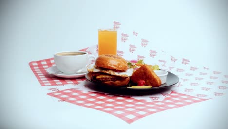 4K-Cinematic-food-footage-of-a-delicious-homemade-burger-displayed-on-a-breakfast-plate-with-orange-juice-and-coffee-in-a-restaurant-on-a-white-background