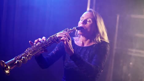 Silueta-De-Una-Mujer-Tocando-Una-Trompeta-En-Un-Club-Nocturno-Focos-De-Neón